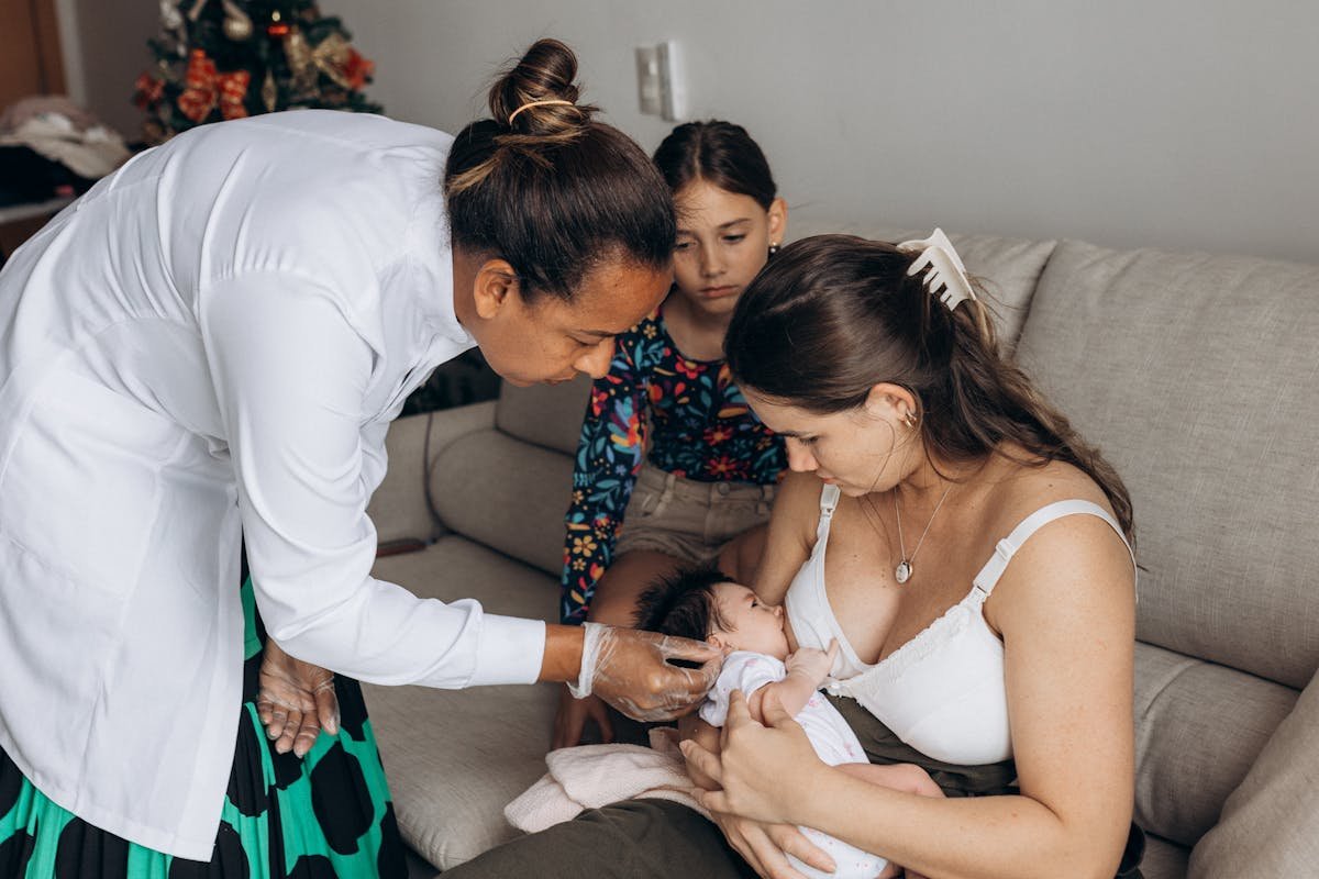 Dicas para preparar a casa para a chegada do bebê após a cesárea A woman holding a baby while another woman looks on