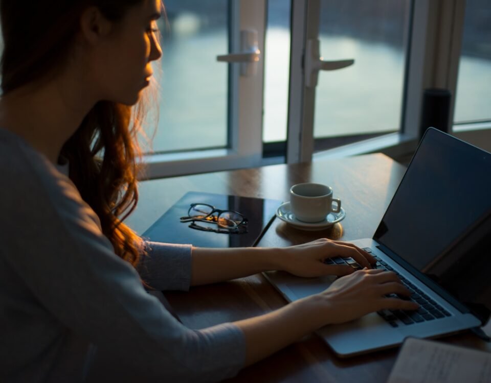 A importância de uma internet estável para o home office woman sitting beside table using laptop