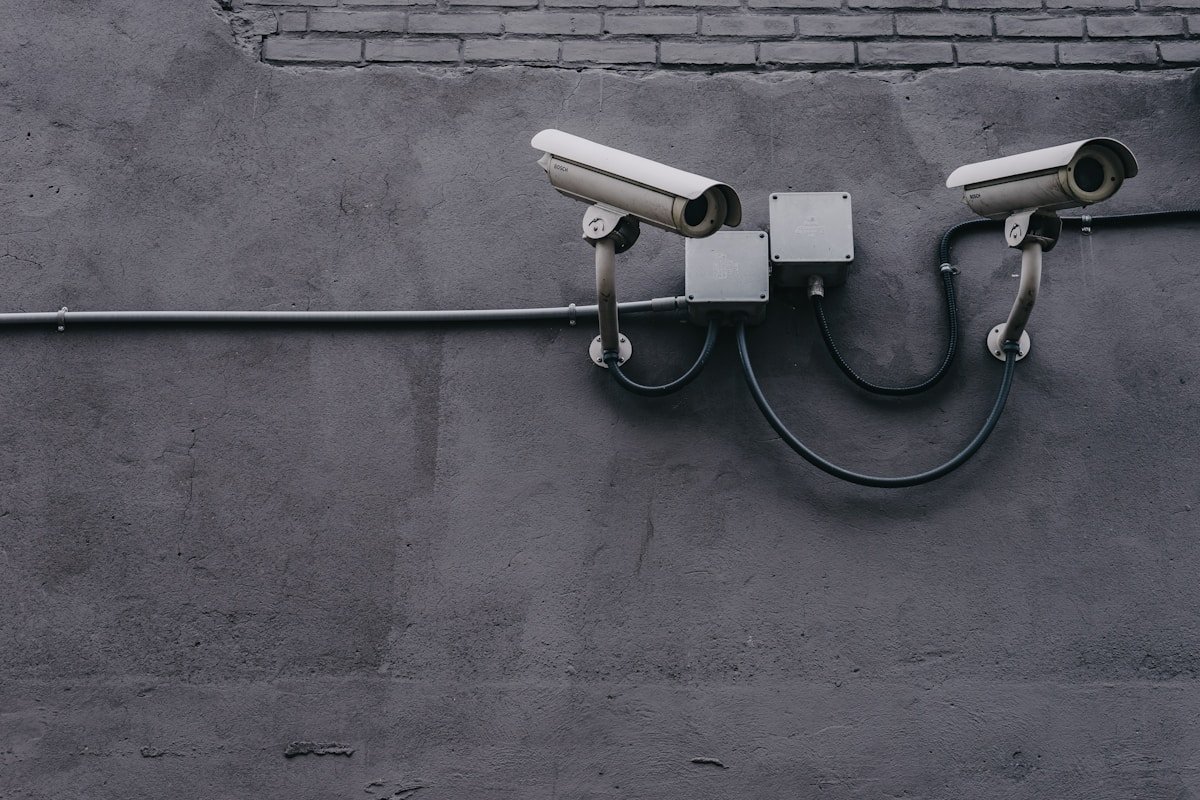 Imóveis em condomínio fechado: vantagens de segurança two bullet surveillance cameras attached on wall