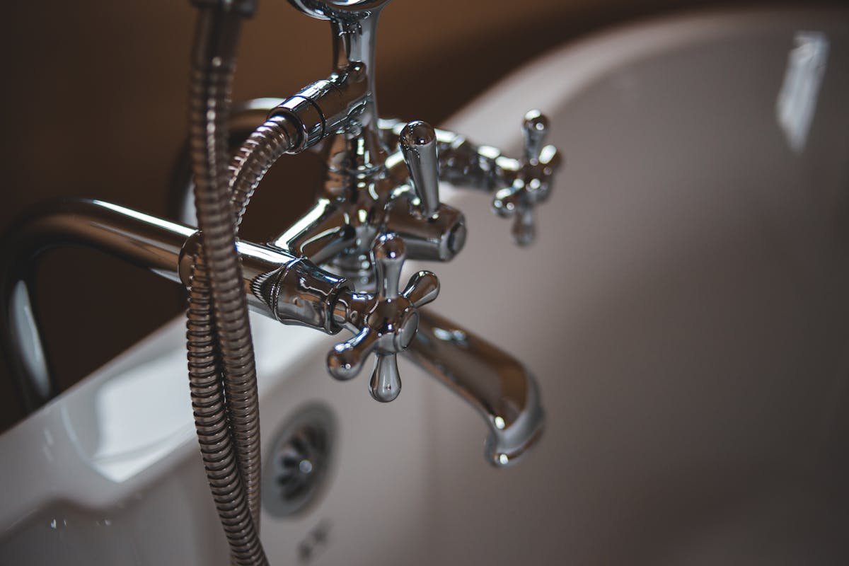 Sistemas de proteção contra vazamentos domésticos Elegant close-up of a shiny chrome faucet in a modern bathroom setting.