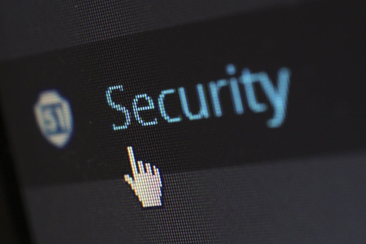 Como cuidados com segurança impactam toda a cadeia de produtos? Close-up view of a mouse cursor over digital security text on display.