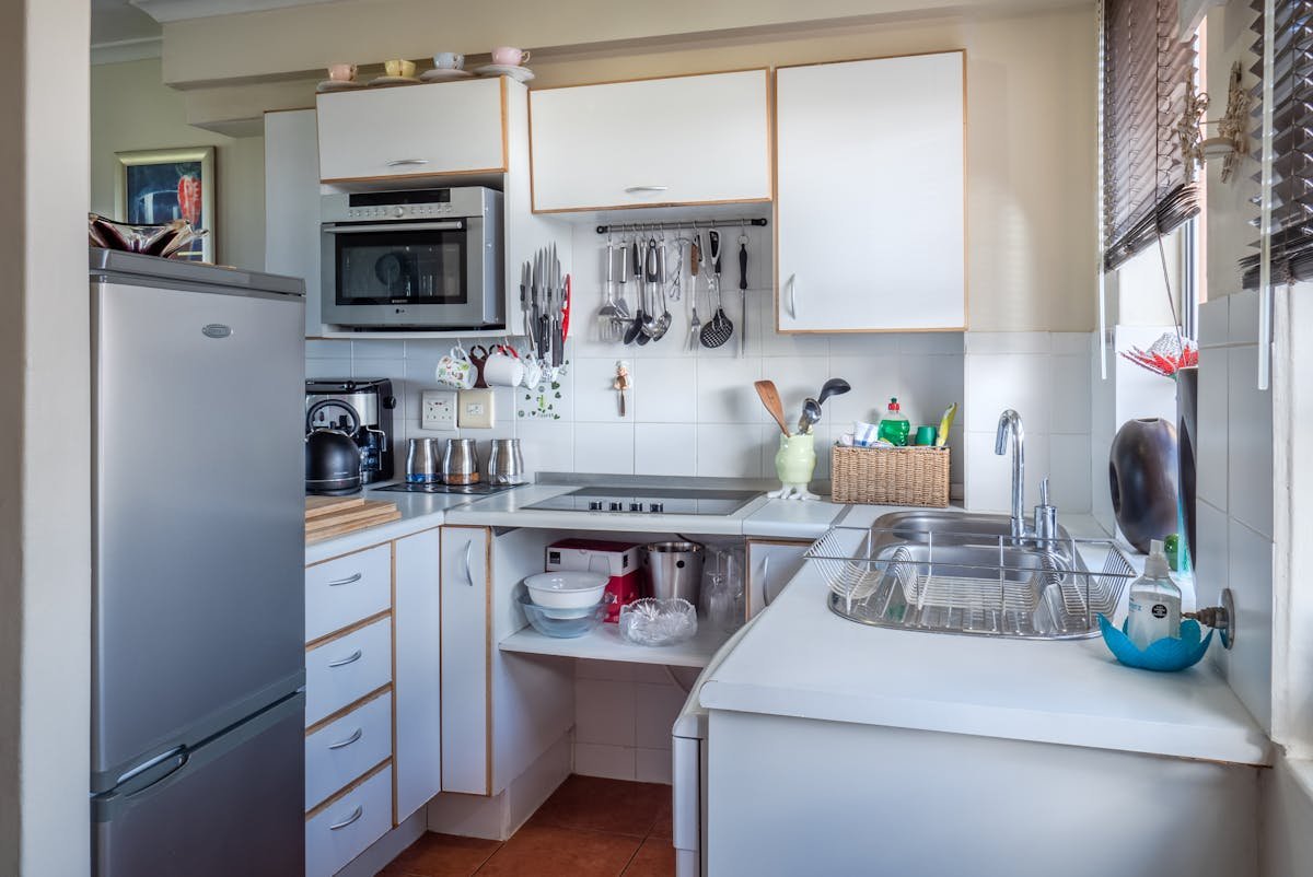 O que considerar ao instalar uma cozinha funcional? Sophisticated kitchen interior with modern appliances, wooden accents, and functional design.