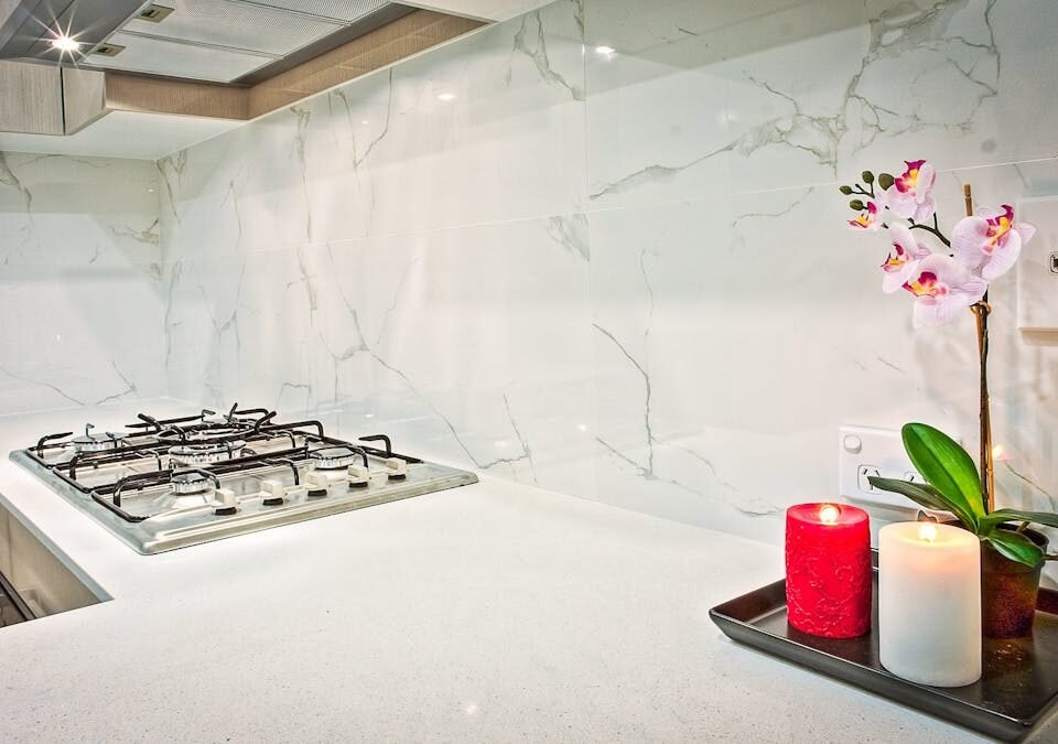 O que considerar ao instalar uma cozinha funcional? Stylish kitchen interior featuring decorative candles and orchids on a countertop.