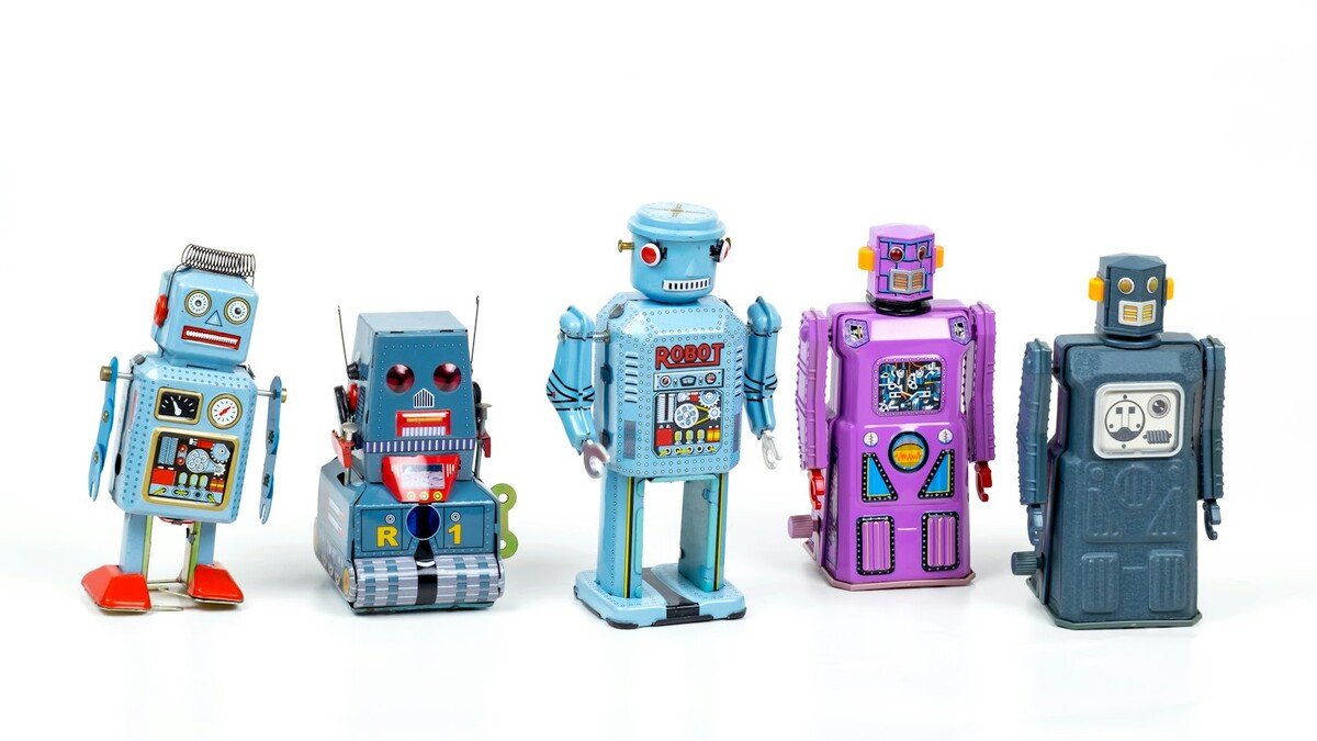 Fileira de robôs de brinquedo coloridos sobre fundo branco