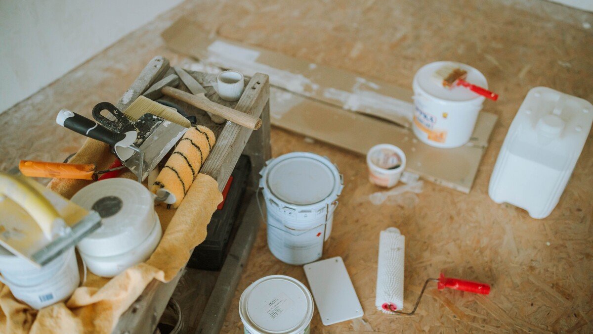 Materiais e ferramentas de pintura organizados para uma reforma residencial.