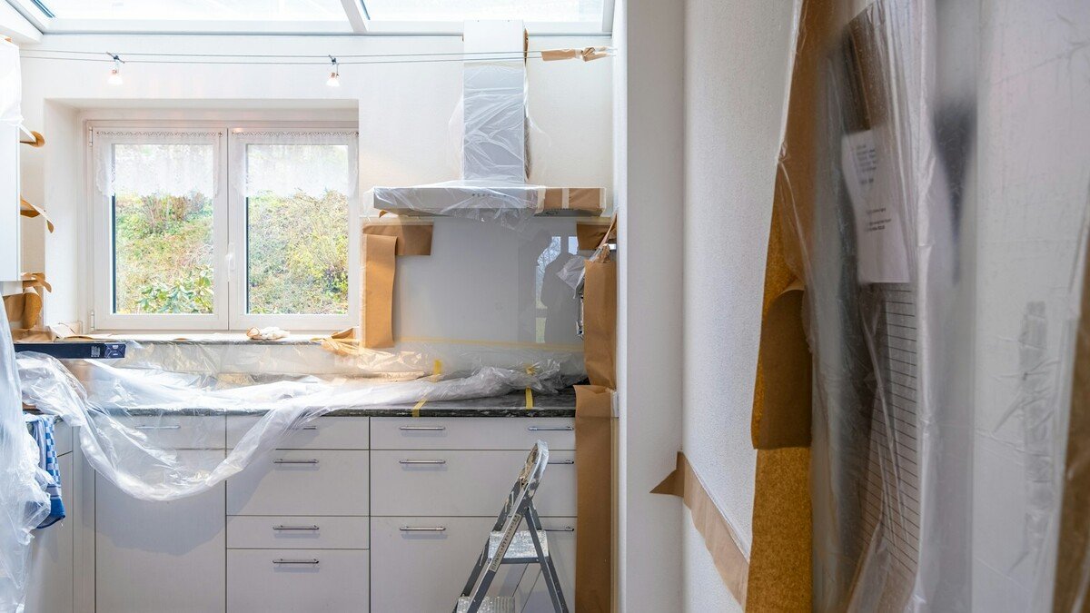 Cozinha em reforma com armários cobertos por plástico e papel