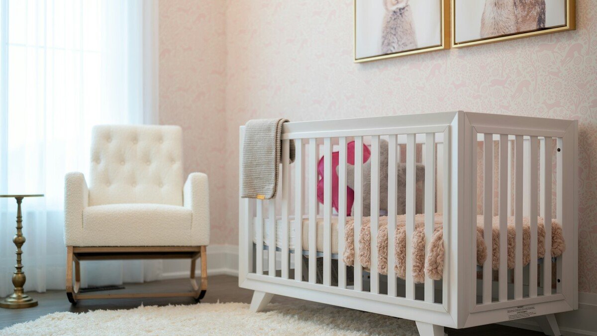 Quarto de bebê com berço branco e poltrona clara