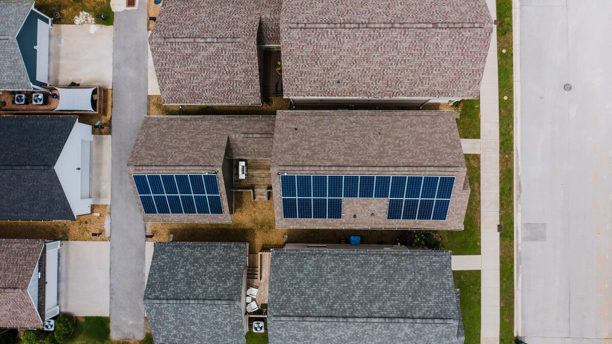 Vista aérea de casas com painéis solares nos telhados