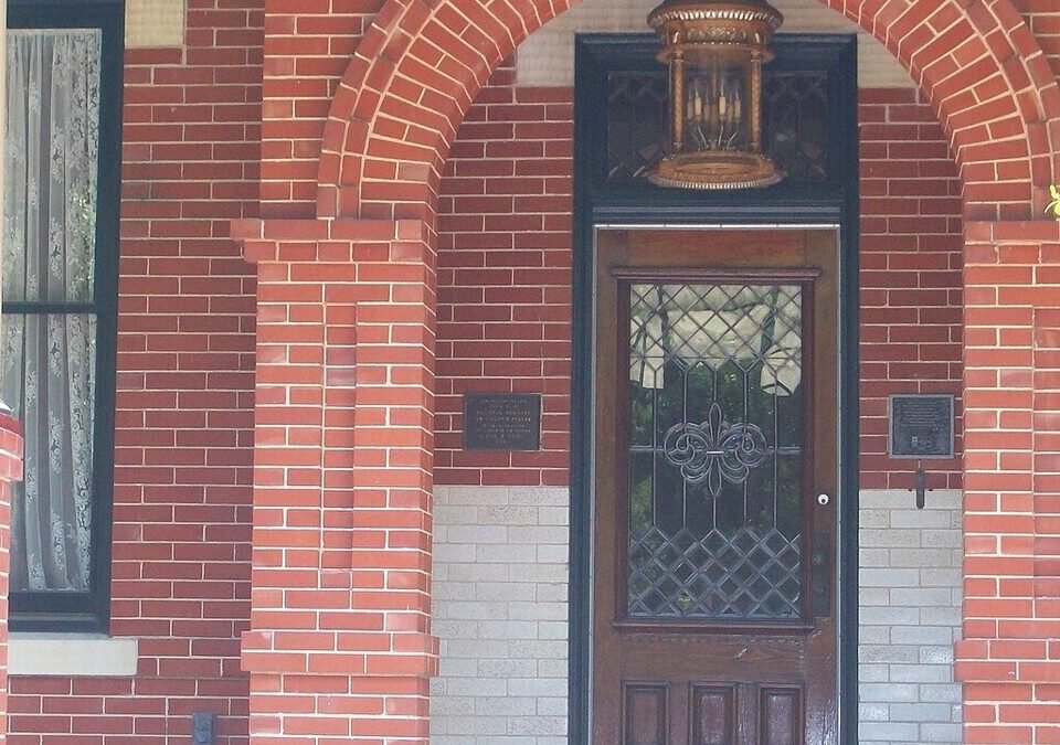 Porta de entrada de madeira de uma casa com fachada de tijolos